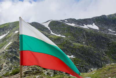 Scenic view of flag on mountain against sky