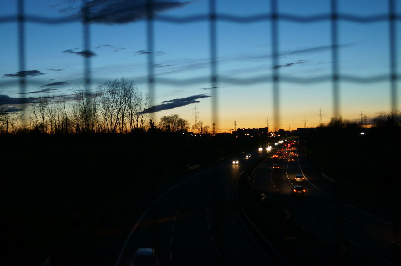 SILHOUETTE TREES BY ROAD AGAINST SKY DURING SUNSET