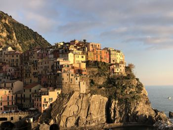 Buildings by sea against sky