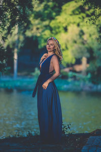 Portrait of woman standing against trees