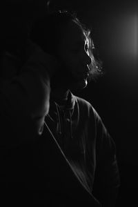 Young man standing in darkroom