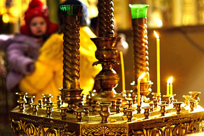 Close-up of illuminated candles in temple