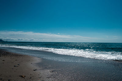 Scenic view of beach against blue sky