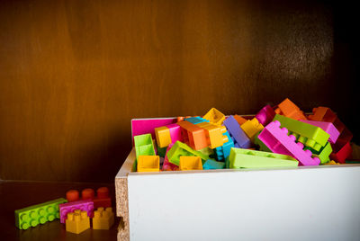 Stack of multi colored toy blocks in container