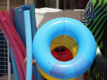 Close-up of multi colored umbrellas hanging against blue wall