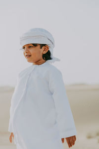 Cute smiling boy standing at desert