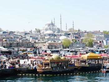 Boats in river with buildings in background