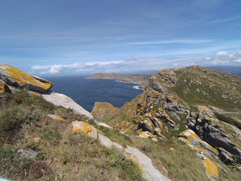 Scenic view of sea by mountains against sky