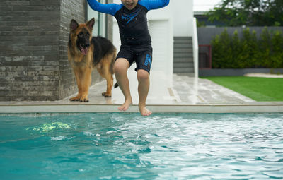 Full length of woman with dog on swimming pool