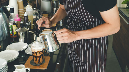 Midsection of man having coffee at cafe