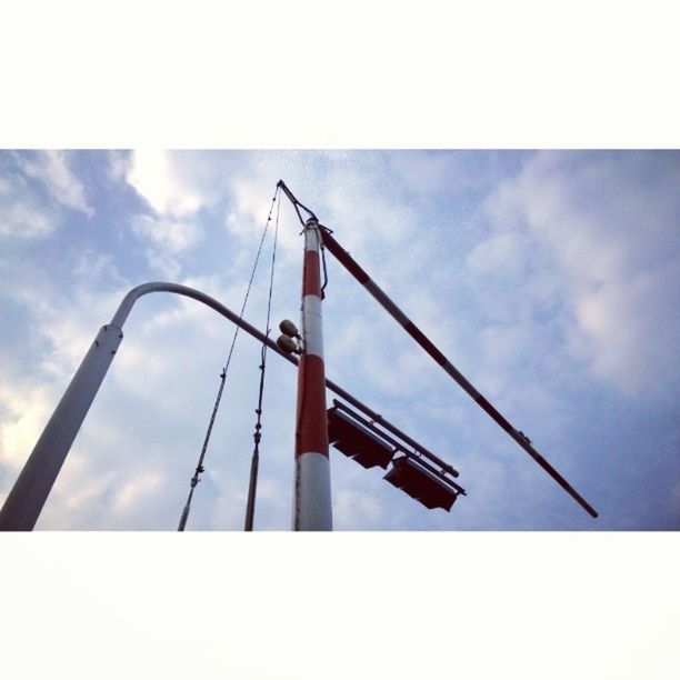 low angle view, transfer print, sky, auto post production filter, cloud - sky, built structure, cloud, architecture, connection, cloudy, day, outdoors, no people, metal, blue, nature, sunlight, engineering, development, overcast