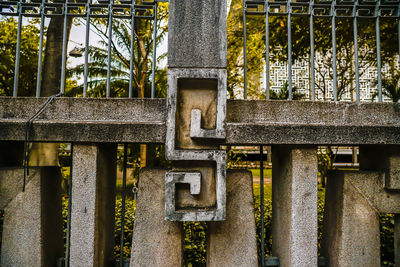 Close-up of metal railing against trees