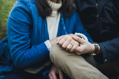 Midsection of boyfriend holding girlfriend hand