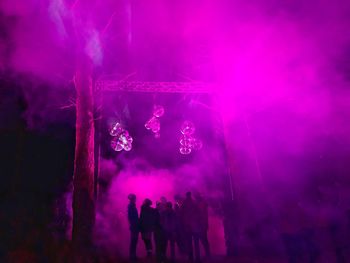 Group of people against illuminated lights