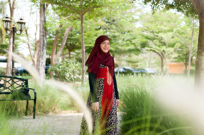 Portrait of smiling woman against trees