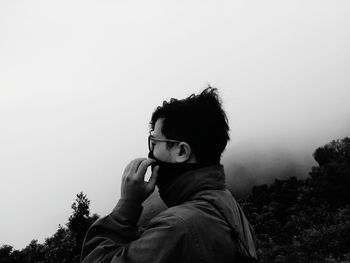 Portrait of boy holding plant against sky