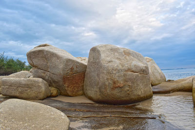 Stack of rocks in sea against sky