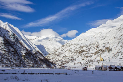 Scenic view of snowcapped mountains against blue sky