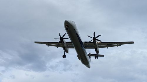 Low angle view of airplane flying against sky