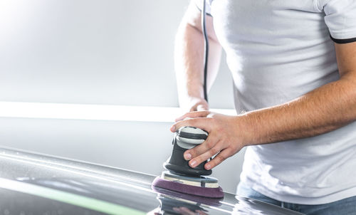 Midsection of man holding car