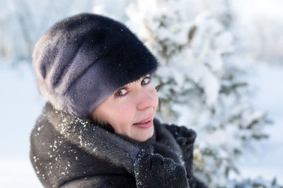 Portrait 40 year old woman in winter clothes on a background of snow.