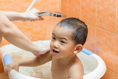 Portrait of shirtless boy in bathroom