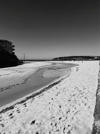 Scenic view of beach against clear sky during winter