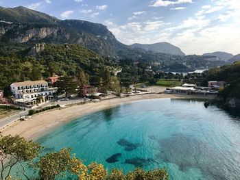 High angle view of clear turquoise sea bay against mountain on corfu island 