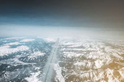 Aerial view of snow coverd landscape against sky