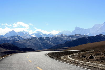 Empty road against mountains