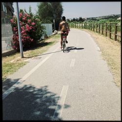 Rear view of woman cycling on road