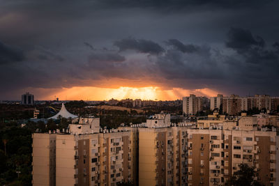 View of buildings in city against sky during sunset