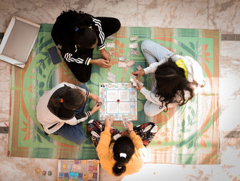 High angle view of girl holding umbrella on floor at home