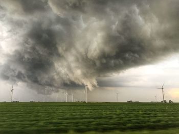 Scenic view of field against cloudy sky