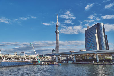 Bridge over river with tokyo skytower and skyline in background