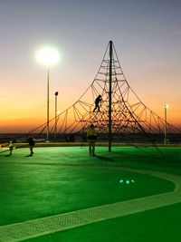 Scenic view of golf course against clear sky during sunset