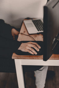 Midsection of man using mobile phone on table