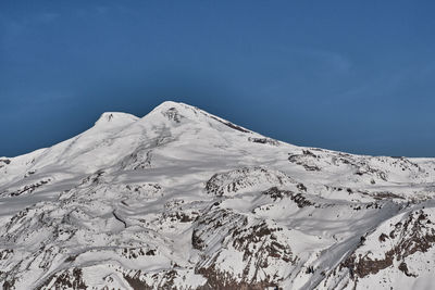 Scenic view of snowcapped mountains against blue sky