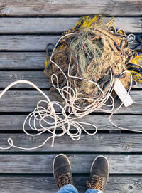 Low section of man by fishing net on boardwalk