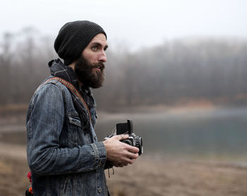 Portrait of young man with camera