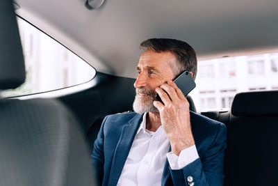 Businessman talking on phone in car