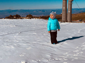 Little boy in the snow of the mountains of sierra nevada