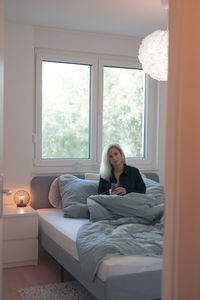 Woman sitting on sofa at home