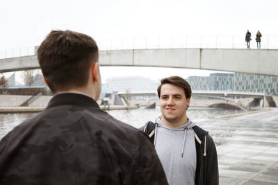 Rear view of man standing on bridge