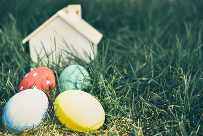 Close-up of multi colored easter eggs with model home on grass