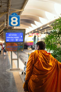 Rear view of man walking in illuminated temple