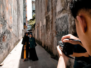 Rear view of woman photographing on wall