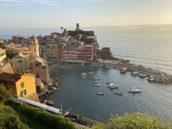 High angle view of townscape by sea against sky during sunset