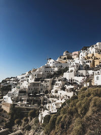 Buildings in city against clear blue sky