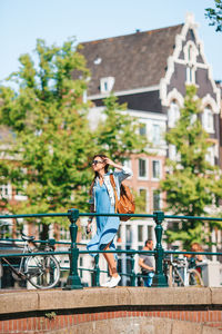 Full length of woman with bicycle in city